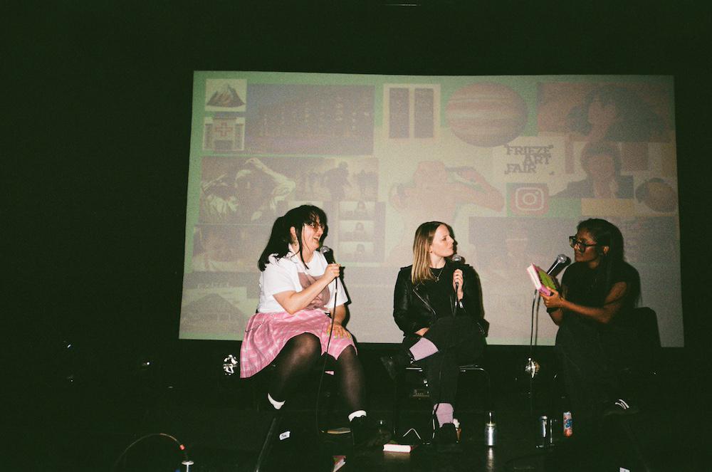 abi palmer, gab and zarina on stage at the ica with microphones and a collage of book topics behind them like a big mad moodboard