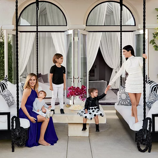 an architectural digest image of Khloe and Kourtney and the kids doing crazy staged poses on outdoor couches