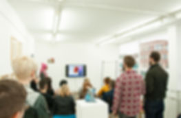 a group of people are gathered for a talk at the exhibition