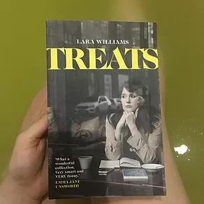 gab holds the book over her legs in the bath, and the water is yellow like the word Treats on the book cover, a title above a woman sitting in a cafe with books in black and white