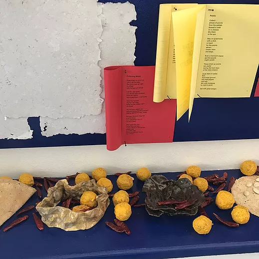 a collection of zines stapled on the wall, and below it on a shelf, there are diiffered dried foods or materials - i can&rsquo;t quite tell