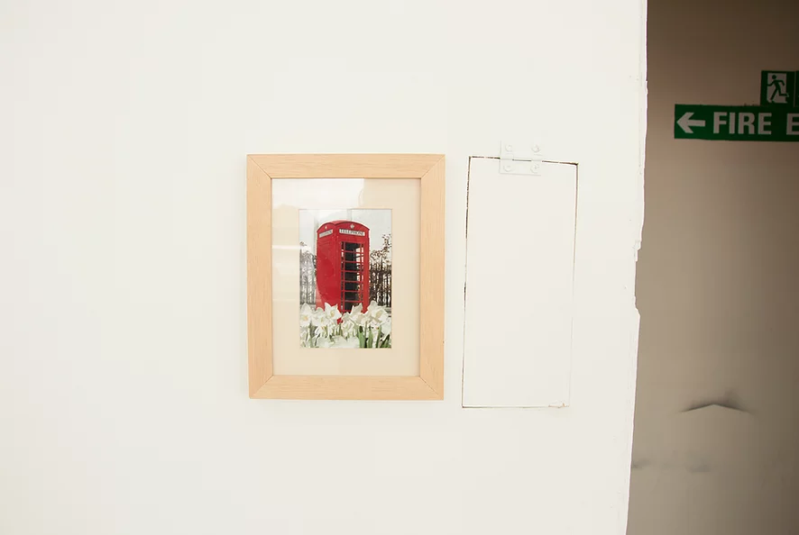 a framed photo of a red phone box