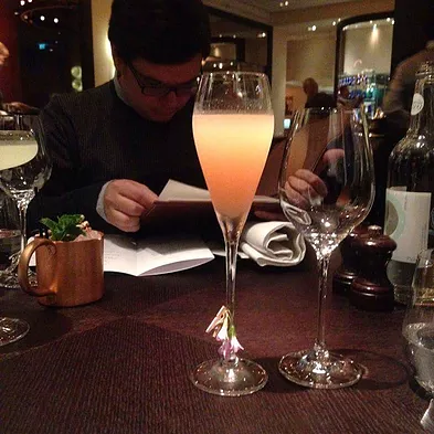 a low shot on the table of a cocktail that is a gradient of orange colours