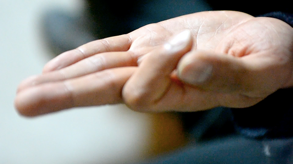 someone has their hand out and they are touching their thumb to their forefinger
