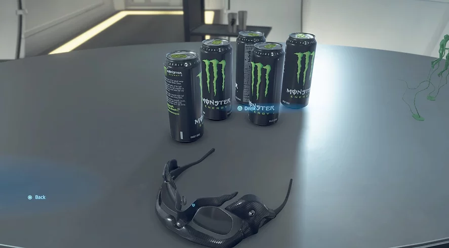 cans of monster energy drink fill the table next to a pair of glasses that aren&rsquo;t quite sun glasses but visors for some strange weather