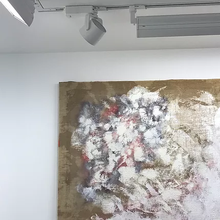 a corner of one of the paintings that is mostly blotches of thin and then thick white paint with much of the canvas below still revealed and patchy