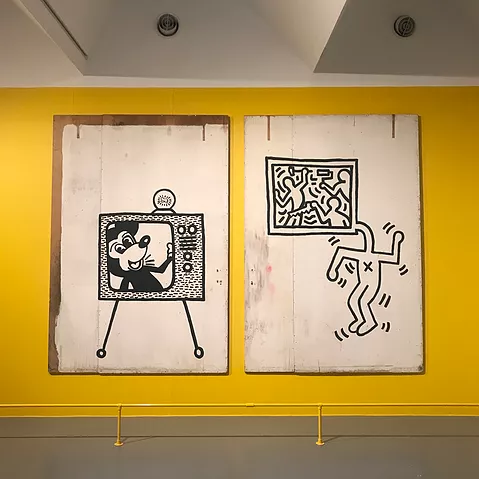 a drawing of an old style tv with a mickey mouse figure smiling on screen, next to a drawing of a figure whose head has stretched out into a TV with people dancing on it