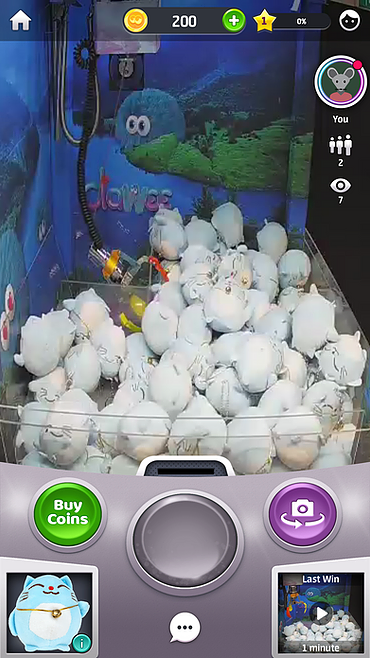 a camera feed into a claw machine shows a flat layer of cat plushies
